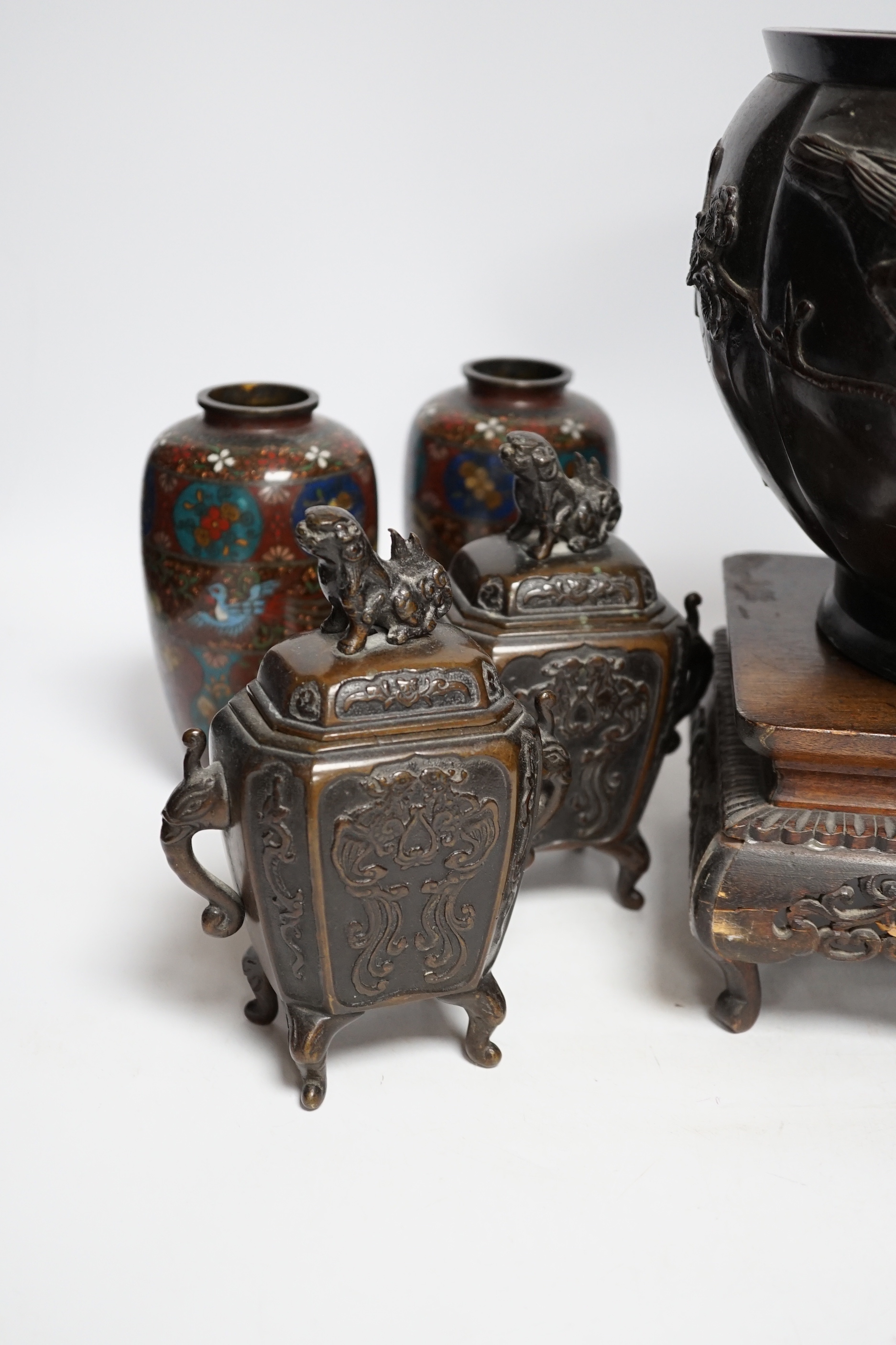 A Meiji period Japanese bronze jardiniere, a pair of cloisonné vases, a hardwood stand, etc.